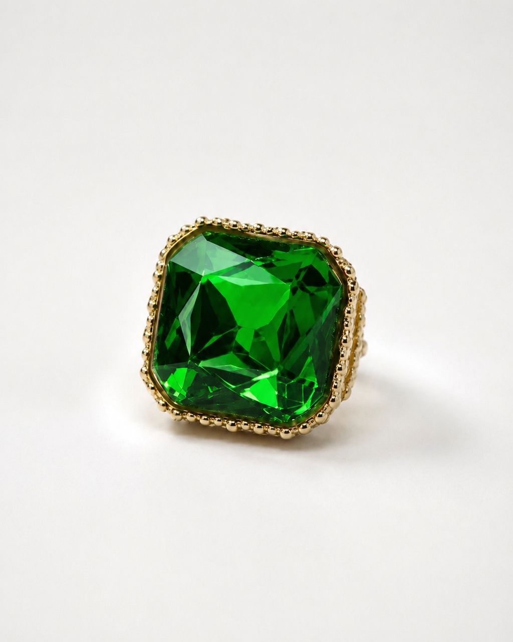Anel dourado com pedra verde quadrada facetada