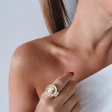 Anel dourado com pingente redondo e detalhe claro