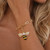 Pulseira em metal dourado com pingente de abelha e detalhes com zircônias