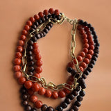 Colar maxi de contas em vermelho, marrom e preto, com argolas e fecho dourado