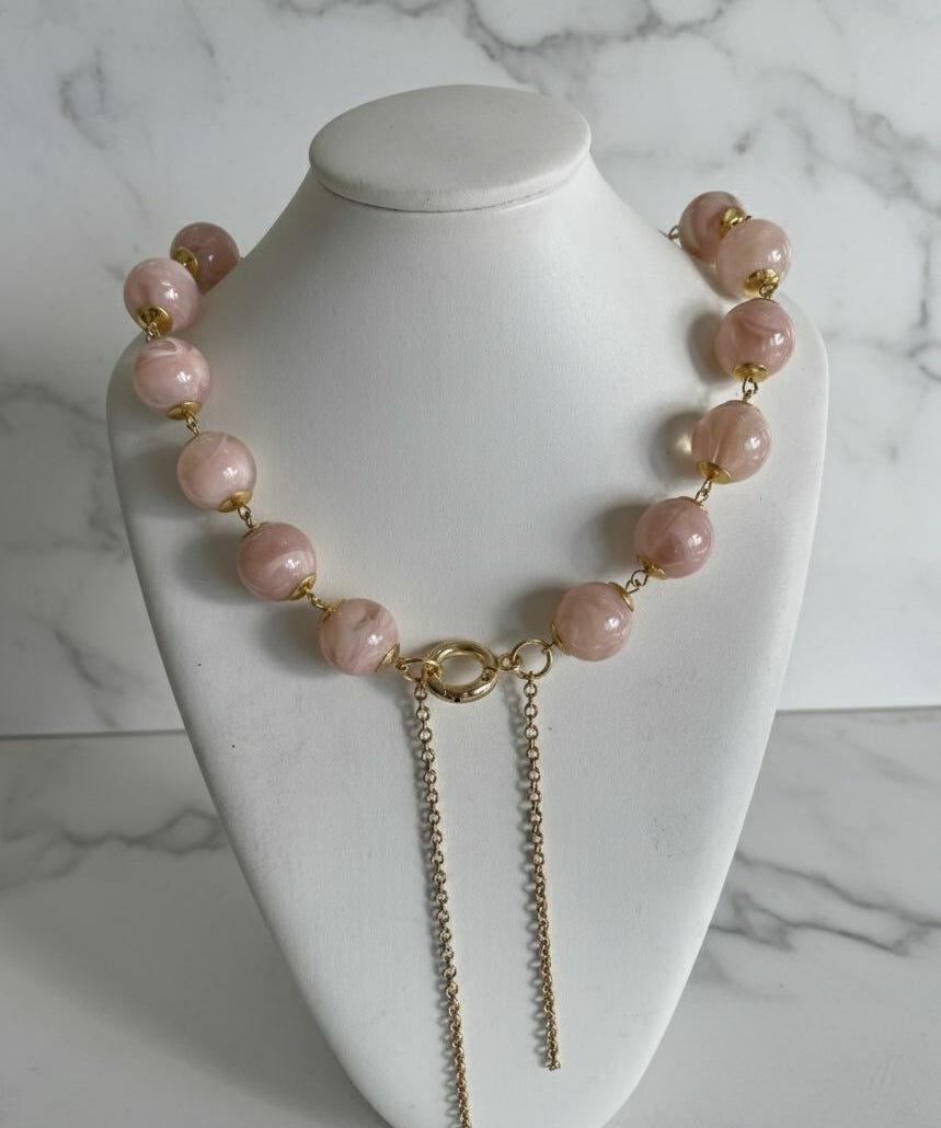 Colar Gloria Slim com contas rosê e fecho dourado, correntes longas pendentes.