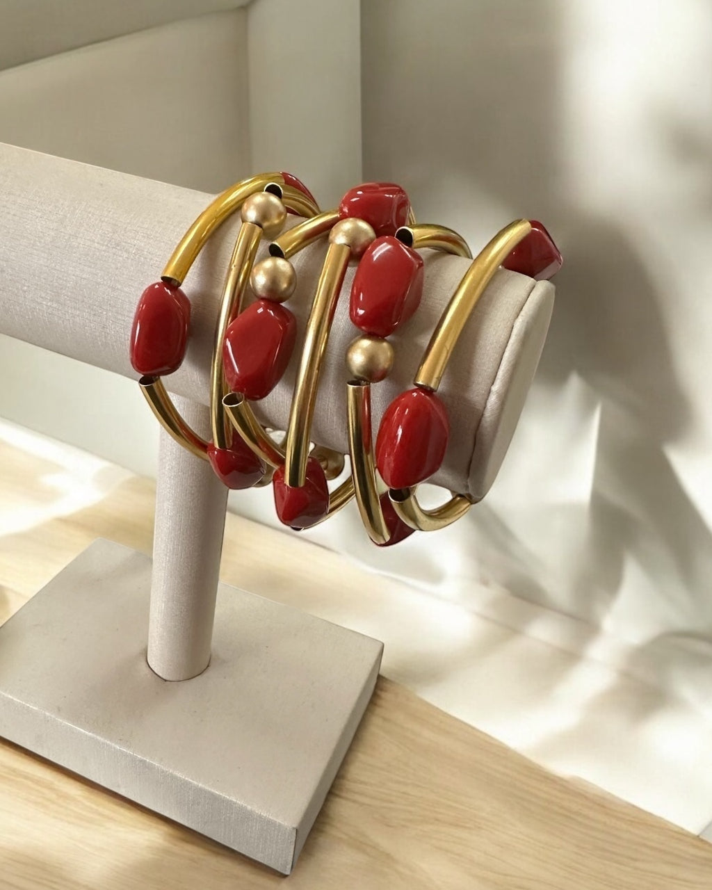Pulseira de argolas douradas com contas vermelhas e esferas douradas