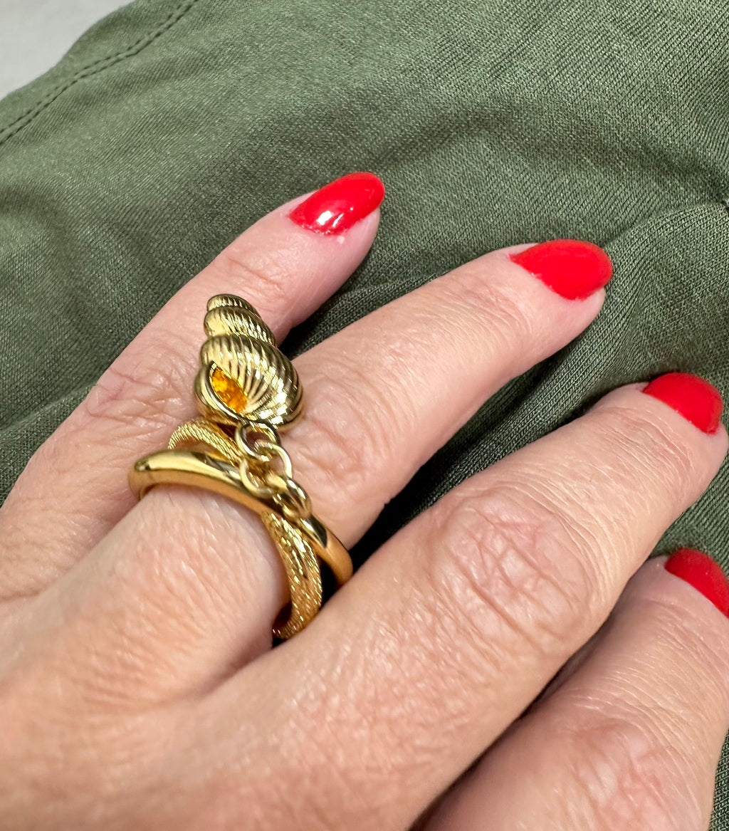 Anel dourado com desenho de caracol, aro vazado e detalhe em espiral