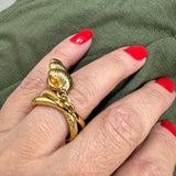Anel dourado com desenho de caracol, aro vazado e detalhe em espiral