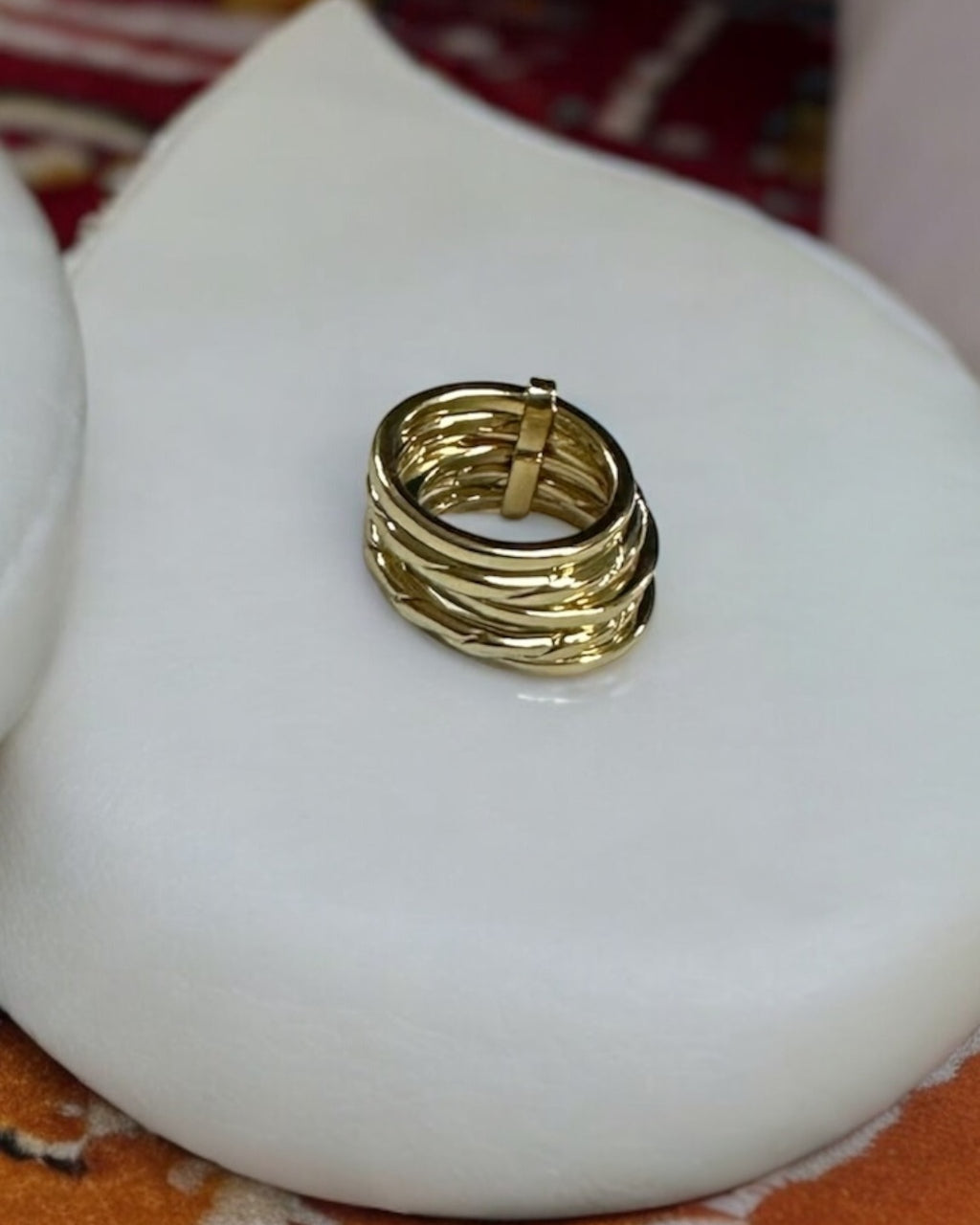 Anel dourado em camadas com desenho trançado e pequena barra no topo