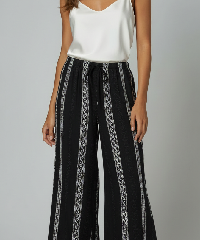 Calça pantalona preta estampada, cintura com cordão e tecido de caimento leve