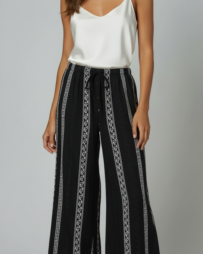 Calça pantalona preta estampada, cintura com cordão e tecido de caimento leve