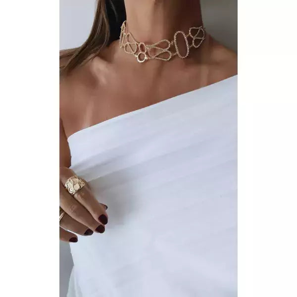 Colar estilo choker em metal com elos vazados em formato de laço na gola