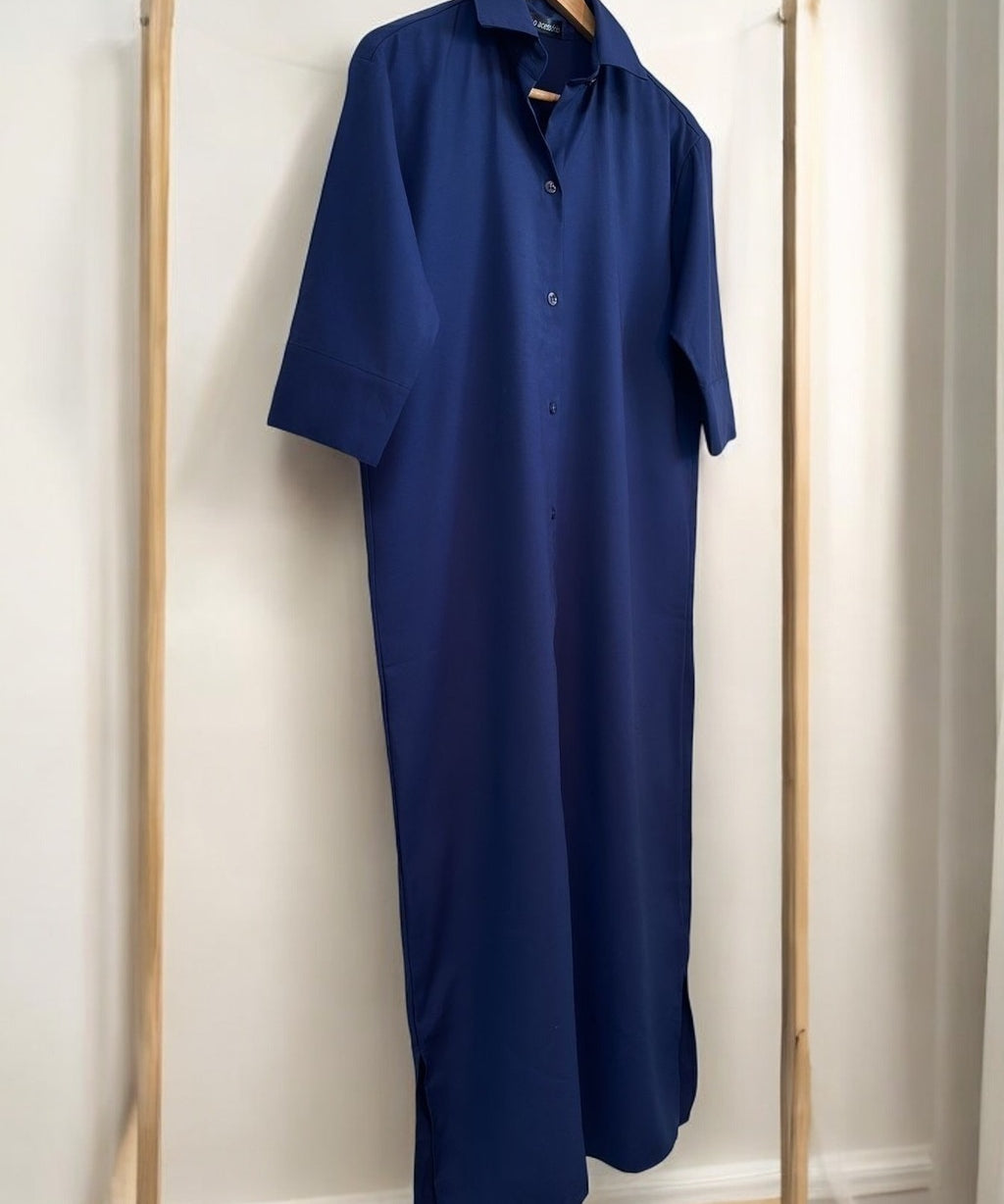 Camisa longa azul marinho, gola e botões frontais, manga curta, caimento reto na vertical.