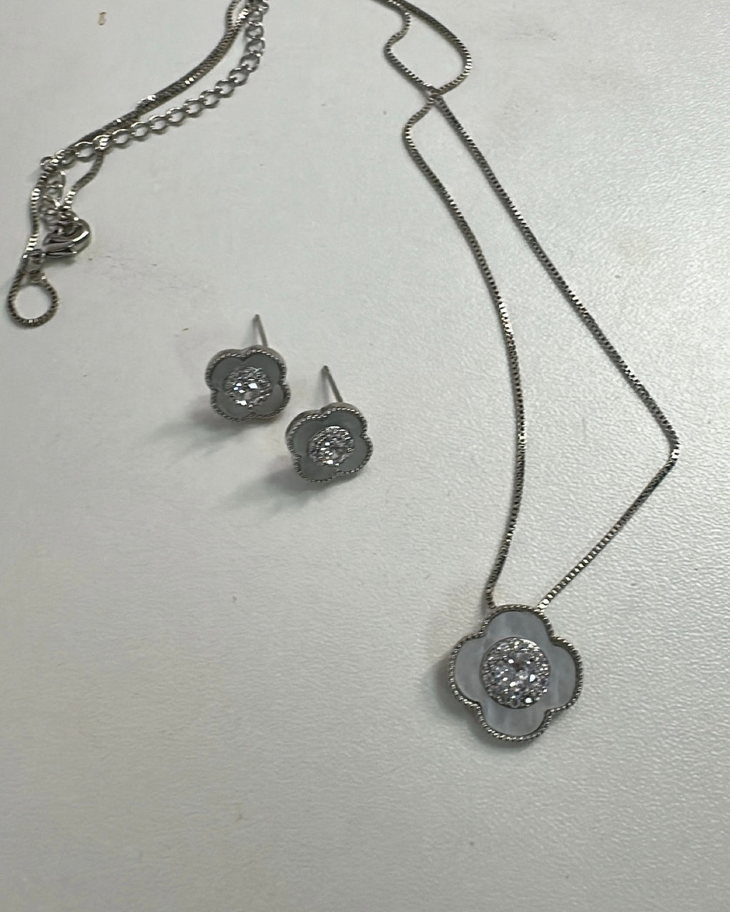 Conjunto Lisbela: colar e brincos prateados com pingente flor e zircônias