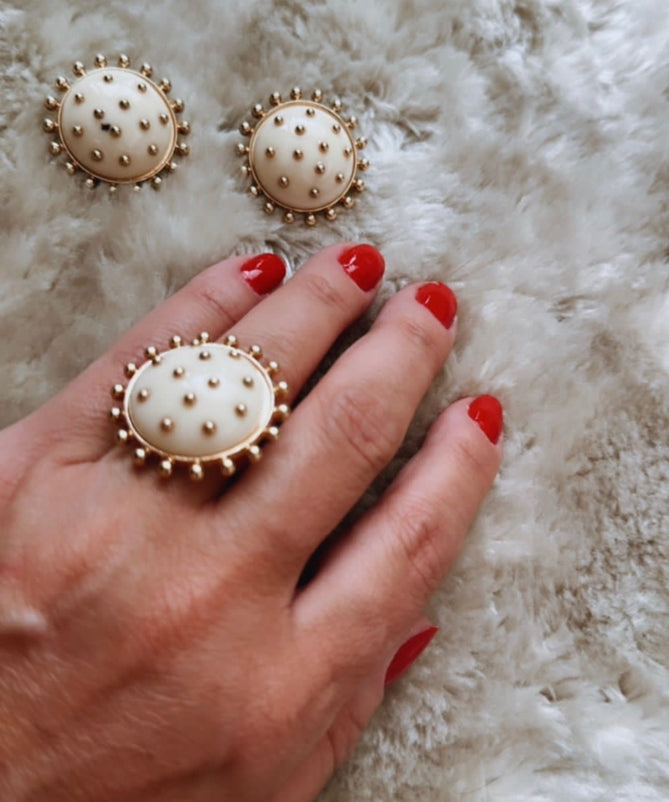 Brinco redondo dourado com base creme e tachas pontilhadas