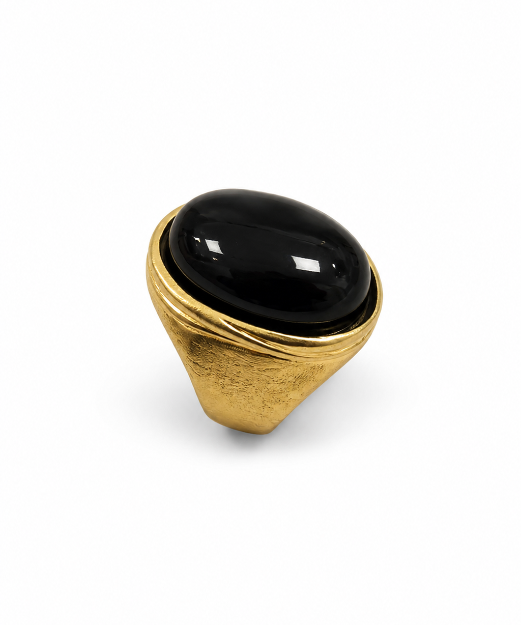 Anel dourado com pedra oval preta brilhante e base arredondada