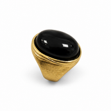 Anel dourado com pedra oval preta brilhante e base arredondada