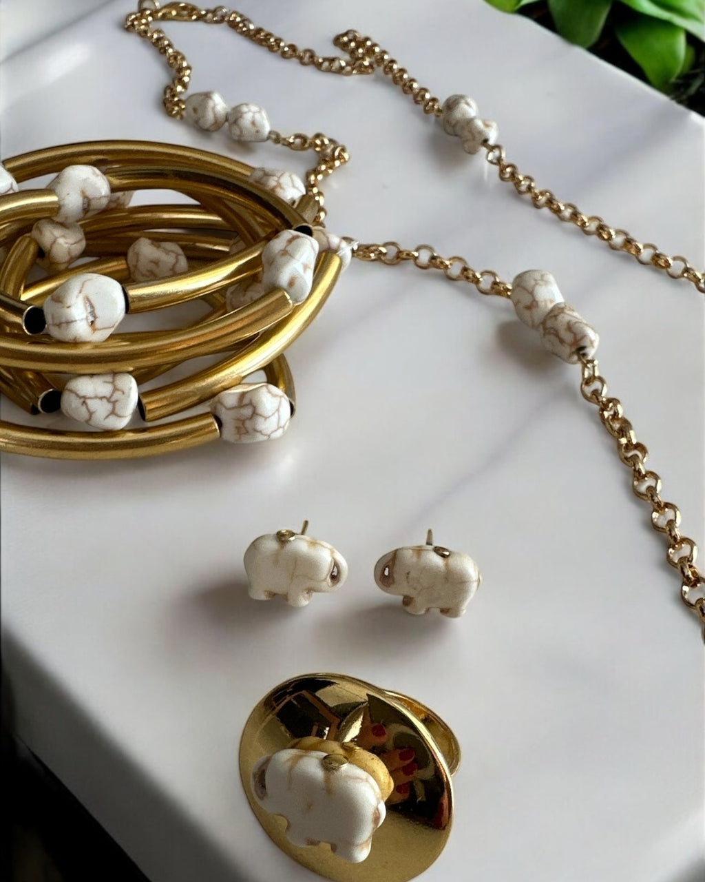 Mix de pulseiras Indra com braceletes dourados e pulseira de corrente com contas brancas