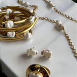 Mix de pulseiras Indra com braceletes dourados e pulseira de corrente com contas brancas