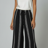 Calça pantalona preta com estampa vertical e cós ajustável por cordão