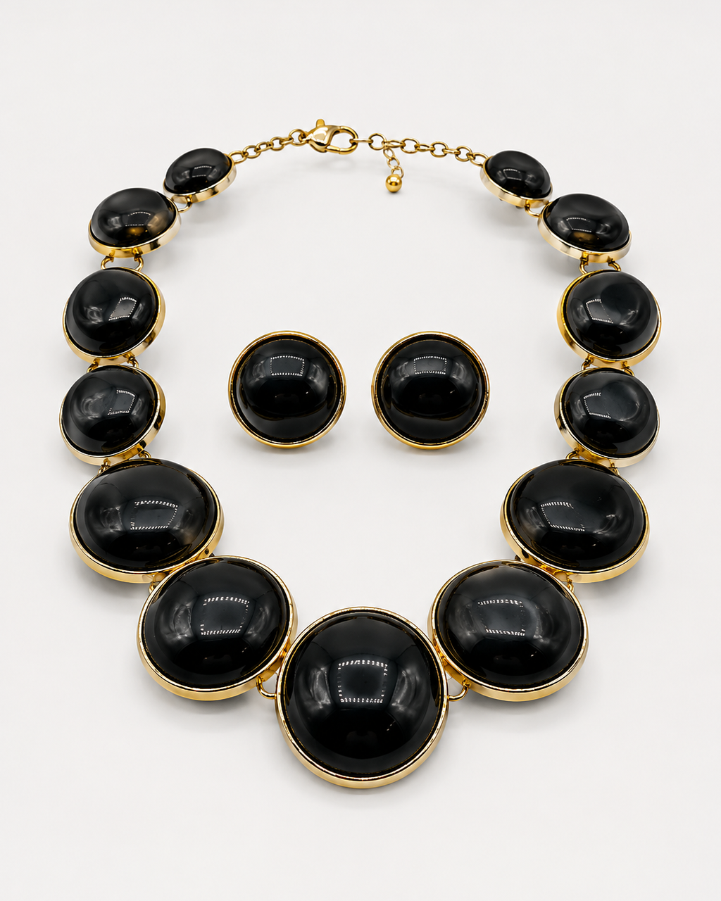 Conjunto de colar e brincos com pedras ovaladas pretas e acabamento dourado