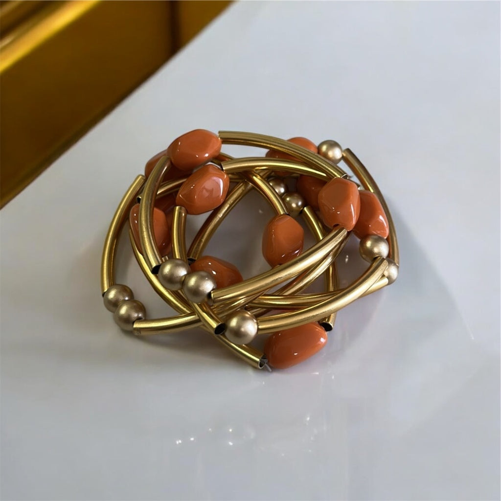 Pulseira de argolas douradas com contas laranja e esferas douradas