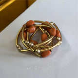 Pulseira de argolas douradas com contas laranja e esferas douradas