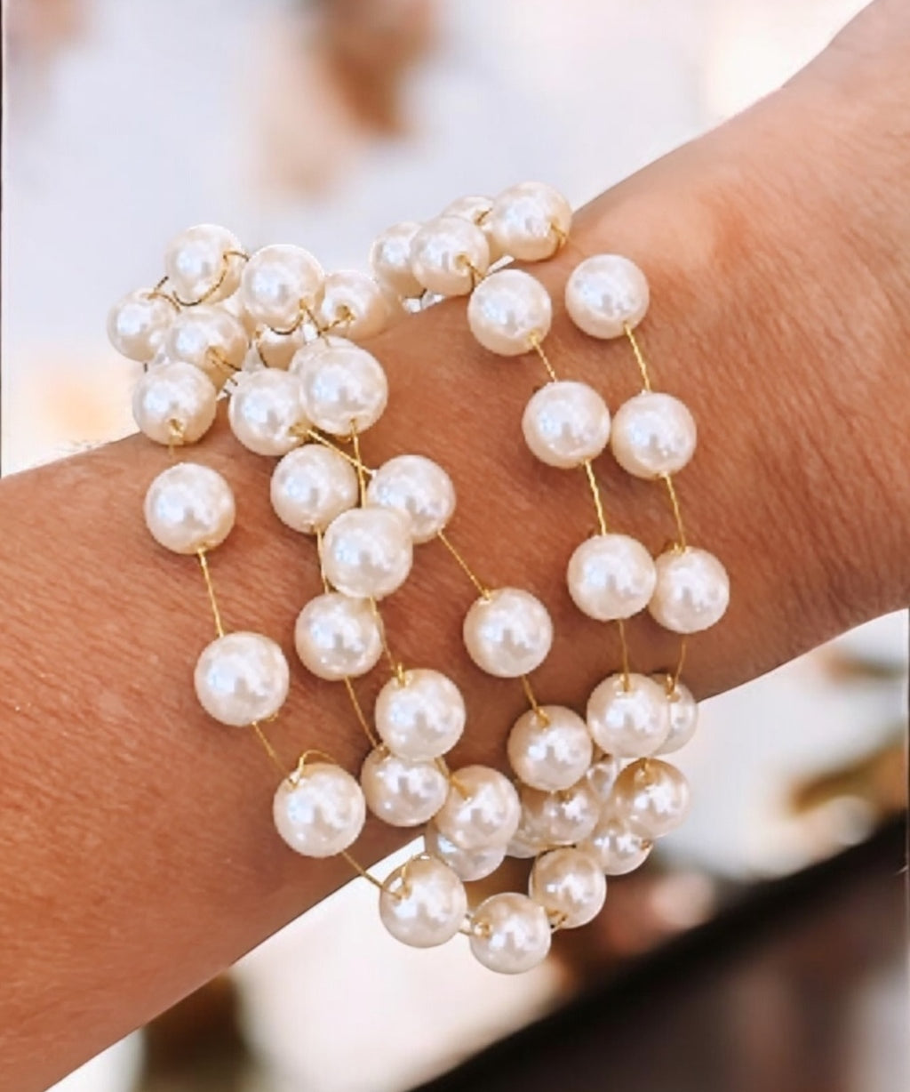 Pulseira dourada com pérolas mini e pingentes esféricos; fecho lagosta e extensor.