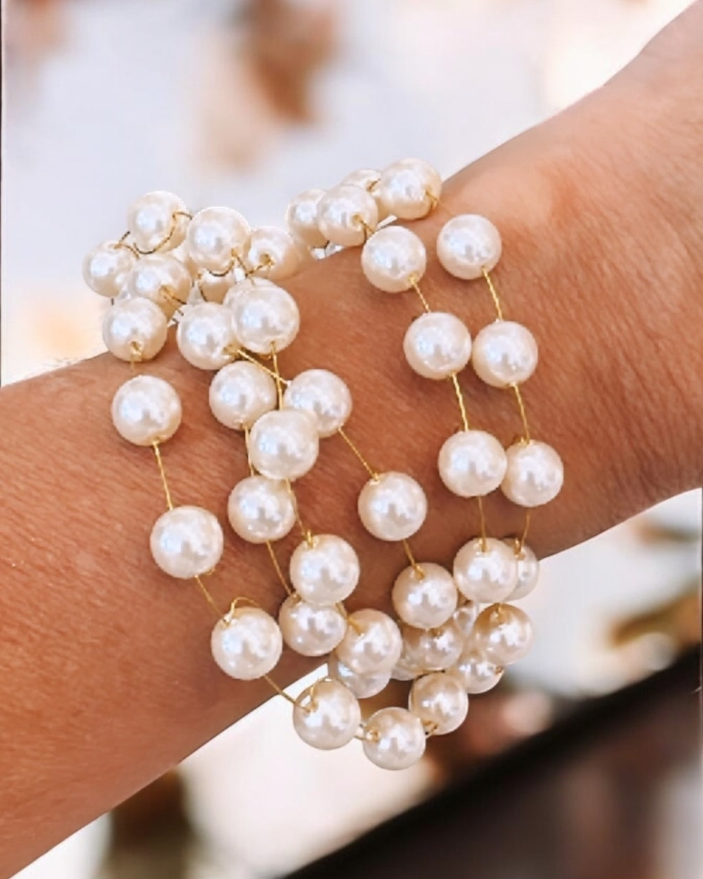 Pulseira dourada com pérolas mini e pingentes esféricos; fecho lagosta e extensor.