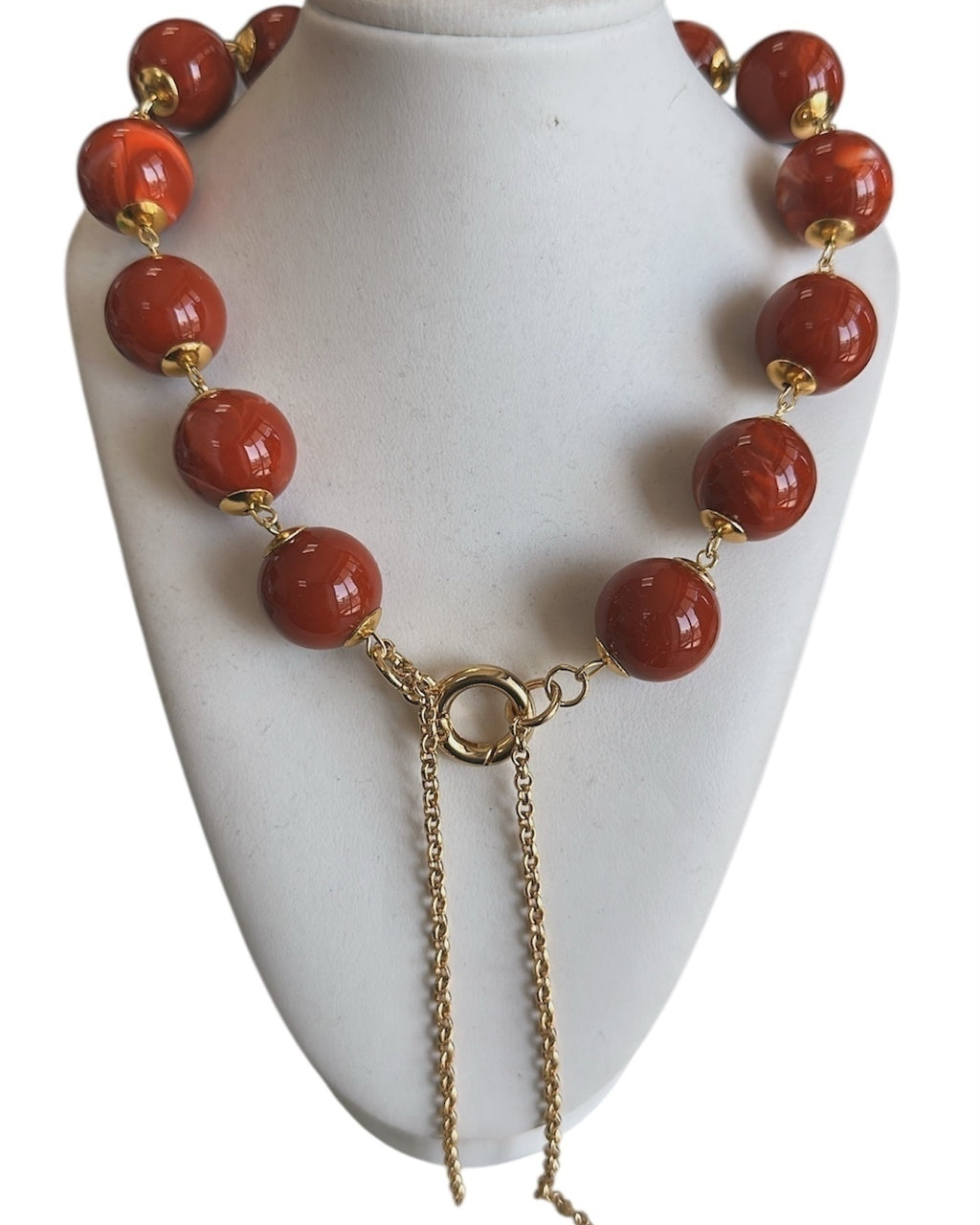 Colar com contas vermelhas e fecho dourado, com correntes pendentes