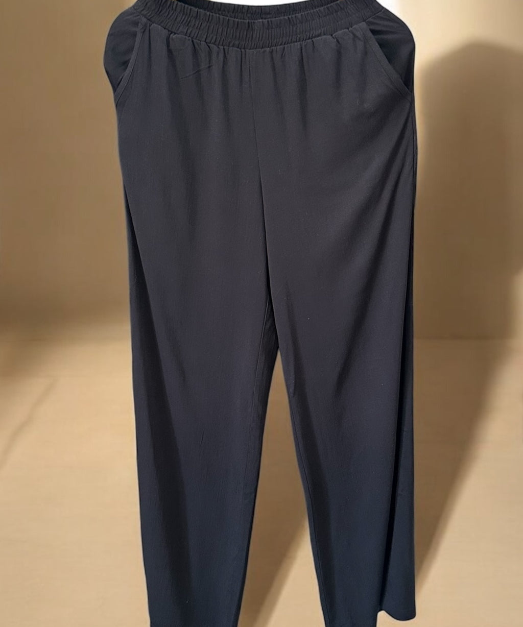 Calça ampla azul escuro com cós elástico e caimento solto, modelo pantacourt