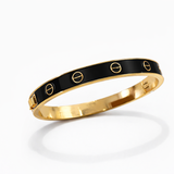 Pulseira Carti metal dourado, base preta com detalhes vazados ovais e fecho.