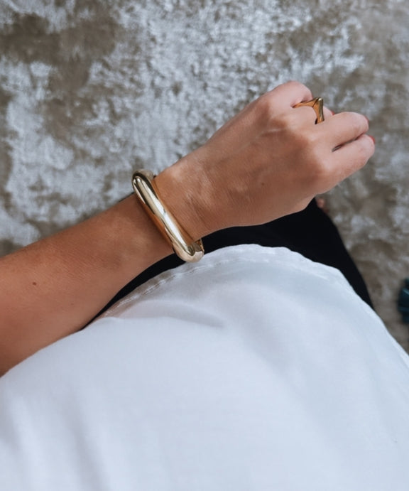 Pulseira Olivia Gold dourada tipo bracelete larga, acabamento polido, fecho discreto.