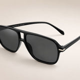 Óculos escuros pretos com lentes escuras e armação arredondada