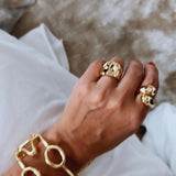 Pulseira dourada com elos circulares e detalhes com acabamento texturizado