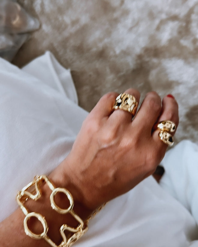Pulseira dourada com elos circulares e detalhes com acabamento texturizado